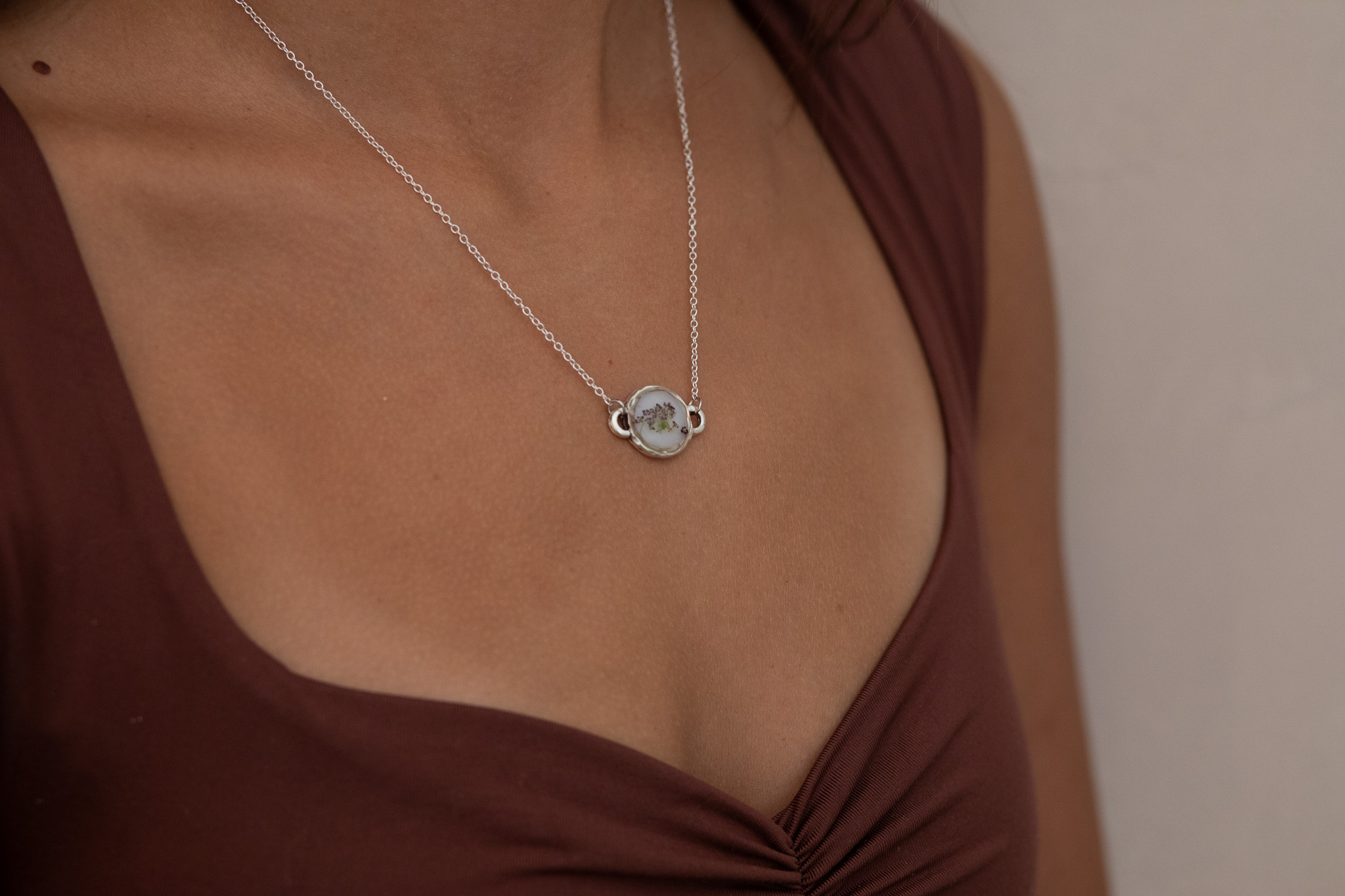 Pressed flower necklace worn in natural light